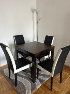 uma mesa preta e quatro cadeiras num quarto em Apartman SARA em Sarajevo