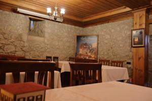ein Restaurant mit Tischen und Stühlen und einem Gemälde an der Wand in der Unterkunft Leyla Hanım Konağı in Safranbolu
