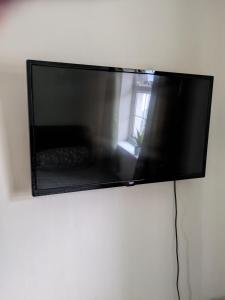 a flat screen tv hanging on a wall at Small but bright single room not far from City Centre in Leicester