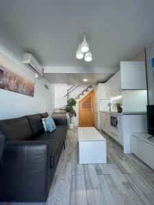 un soggiorno con divano e cucina di Casa Dunaflor a Maspalomas