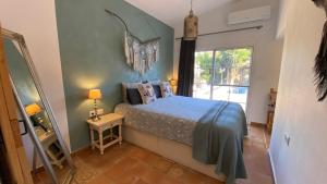 a bedroom with a bed and a window and a mirror at Finca del Gecko in Alhaurín el Grande