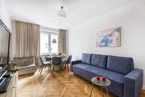 a living room with a blue couch and a table at 7Heaven Dream - City Center in Warsaw