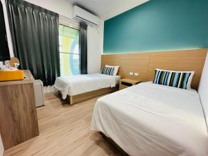 a hotel room with two beds and a window at Qing Taoyuan Homestay in Hengchun South Gate