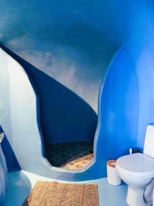 a blue and white bathroom with a toilet at Lioyerma Cave Villa With Private Outdoor Hot Tub in Oia