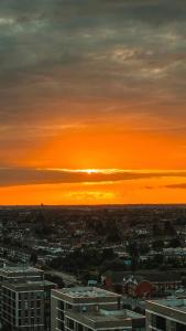 um pôr-do-sol sobre uma cidade com edifícios e o céu em Modern 14th Floor 1or2-Bed Flat em Dagenham