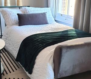 a bed with a black and white blanket on it at Top Spot 2-Bed Spacious Apartment Town Centre Train Station WIFI in Colchester
