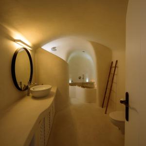 a bathroom with a sink and a mirror at Kamares Apartments in Fira