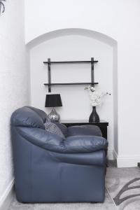 een blauwe bank in een woonkamer met een lamp bij Beautiful and spacious 4- bedroom house in Sunderland in Pallion