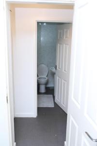 a bathroom with a toilet and a door open at Beautiful and spacious 4- bedroom house in Sunderland in Pallion