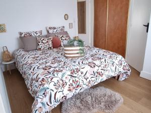 een slaapkamer met een bed met een bloemrijke sprei bij Les Castors in Carcassonne