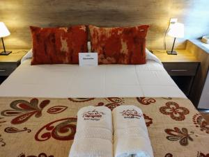 Una cama con dos pares de calcetines. en Luna de Cafayate Hotel Boutique en Cafayate