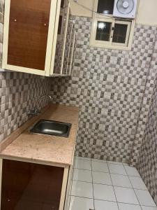 uma cozinha com um lavatório e uma parede em azulejo em Al Joud Palace Residential Units em Abha