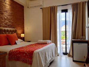 a bedroom with a bed and a large window at Luna de Cafayate Hotel Boutique in Cafayate