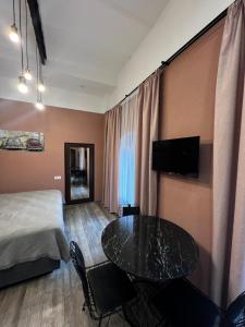 a hotel room with a bed and a table and a bed at Chikhi in Tbilisi City