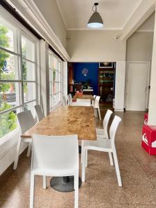 a dining room with a wooden table and white chairs at Hostel Playa Grande Austral in Mar del Plata
