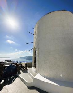 - un bâtiment blanc avec vue sur l'océan dans l'établissement Lioyerma Windmill Villa With Outdoor Hot Tub, à Oia