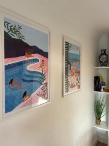 deux peintures sur un mur à côté d'une piscine dans l'établissement Superbe studio port Fréjus 2 - 800m de la plage, à Fréjus