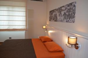 a bedroom with a bed with two orange pillows at Terraeccellente B&B in Acquaviva delle Fonti