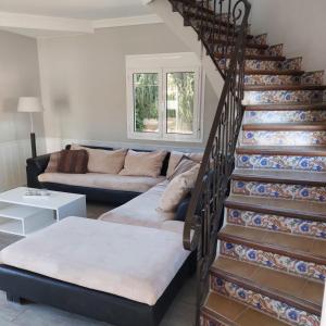 een woonkamer met een trap en een bank bij Villa voor 8 personen met zwembad in Calafat