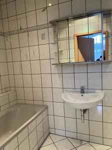 a bathroom with a sink and a bath tub at Ferienwohnung in Walddorf