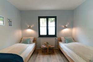 two beds in a room with a window at Ferienhaus Berg'nSee in Annenheim