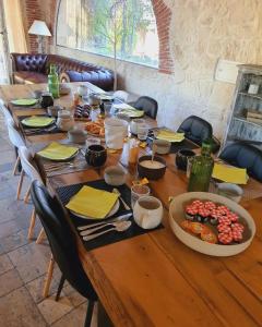 een lange houten tafel met borden eten erop bij Le Mas de Mougins in Mougins