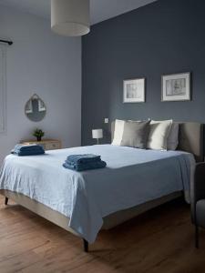 a bedroom with a large bed with blue walls at The sunny house in Athens