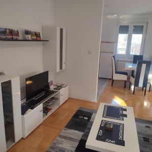 a living room with a television and a table at Black and White in Pirot