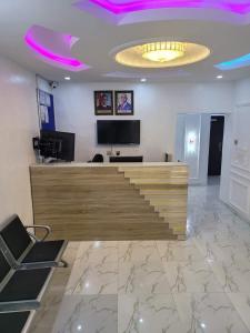 um átrio com uma escada num quarto com luzes roxas em B&Y ROYAL BAR & LOUNGE ADIGBE ROAD MONIJESU NEAR ADIGBE POLICE STATION em Abeokuta