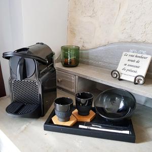 a coffee maker and four cups on a counter at Le Mas de Mougins in Mougins