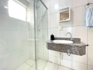 une salle de bain avec un lavabo et une douche dans l'établissement Centro de Barra velha - 550m do Mar, à Barra Velha 13 autres photos