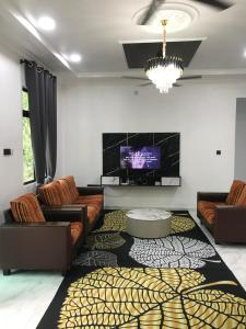 a living room with couches and a tv at AINUL HOMESTAY in Pasir Mas