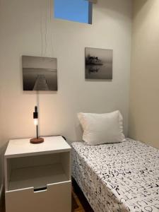 a bedroom with a bed and a nightstand with a lamp at Cosy and Renewed T2 Apartament in Campolide - 67 1D in Lisbon
