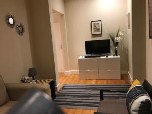 a living room with a couch and a television at Cosy and Renewed T2 Apartament in Campolide - 67 1D in Lisbon