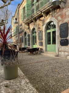 a building with a potted plant in front of it at Hôtel De L'Horloge in Auvillar