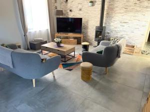 ein Wohnzimmer mit einem Sofa, Stühlen und einem Kamin in der Unterkunft Belle Maison tourangelle pour 6 personnes in Chambourg-sur-Indre