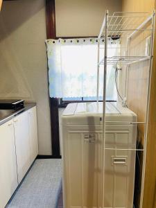 a kitchen with a washer and dryer next to a window at 難波心斎橋10minutes民宿2号室 in Osaka