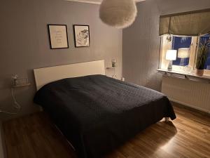 una camera con un letto e una coperta nera di Cozy guesthouse in Slussfors, Swedish Lapland a Slussfors