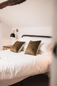 a bedroom with a white bed with two pillows at Bankers Room + Kitchenette in Chapel en le Frith