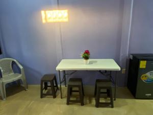 a table with stools and a vase with a flower on it at Casa Púrpura in La Cruz