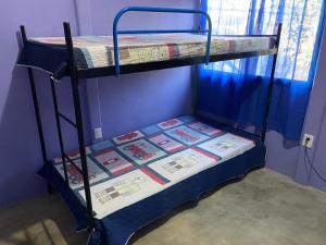 a bunk bed in a room next to a window at Casa Púrpura in La Cruz