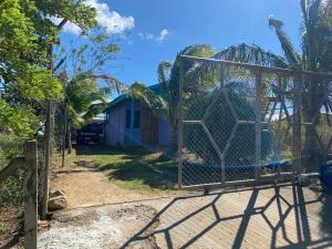 a gate in front of a house with a blue building at Casa Púrpura in La Cruz