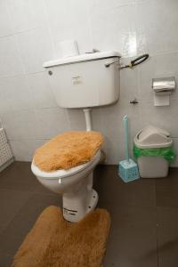 een badkamer met een toilet en een bruin tapijt bij Freeman Methodist Guest House 