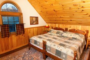 a bedroom with a bed in a log cabin at Trails End Inn in Keene Valley