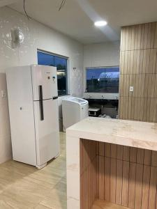 a kitchen with a white refrigerator in a room at Casa Festival de Parintins 2024 II in Parintins