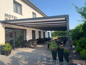 a patio with tables and chairs in front of a hotel at Hotel Restaurant Ayhan in Burgdorf