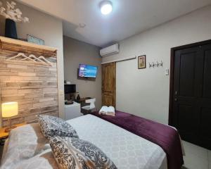 una camera con un grande letto e una TV di Villa San Valentin a San Pedro Sula