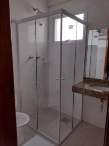 een glazen douche in een badkamer met een wastafel bij Hotel Mãe Peregrina in Aparecida