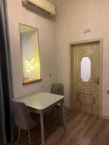 Habitación con mesa, sillas y espejo. en Central apartment in Baku, en Baku