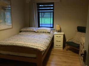 1 dormitorio con cama, ventana y silla en Room to rent en Mullingar